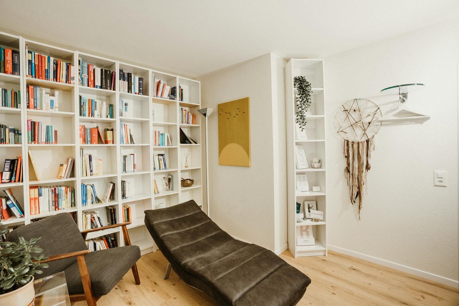 A serene reading area featuring a bookshelf, comfortable chair, and decorative elements.