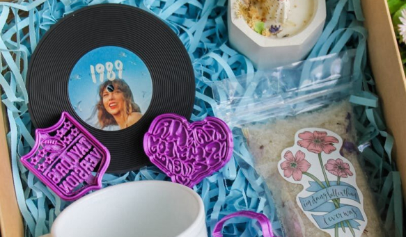 Charming gift box with vinyl record, mug, and bath products on grass, perfect for music lovers.